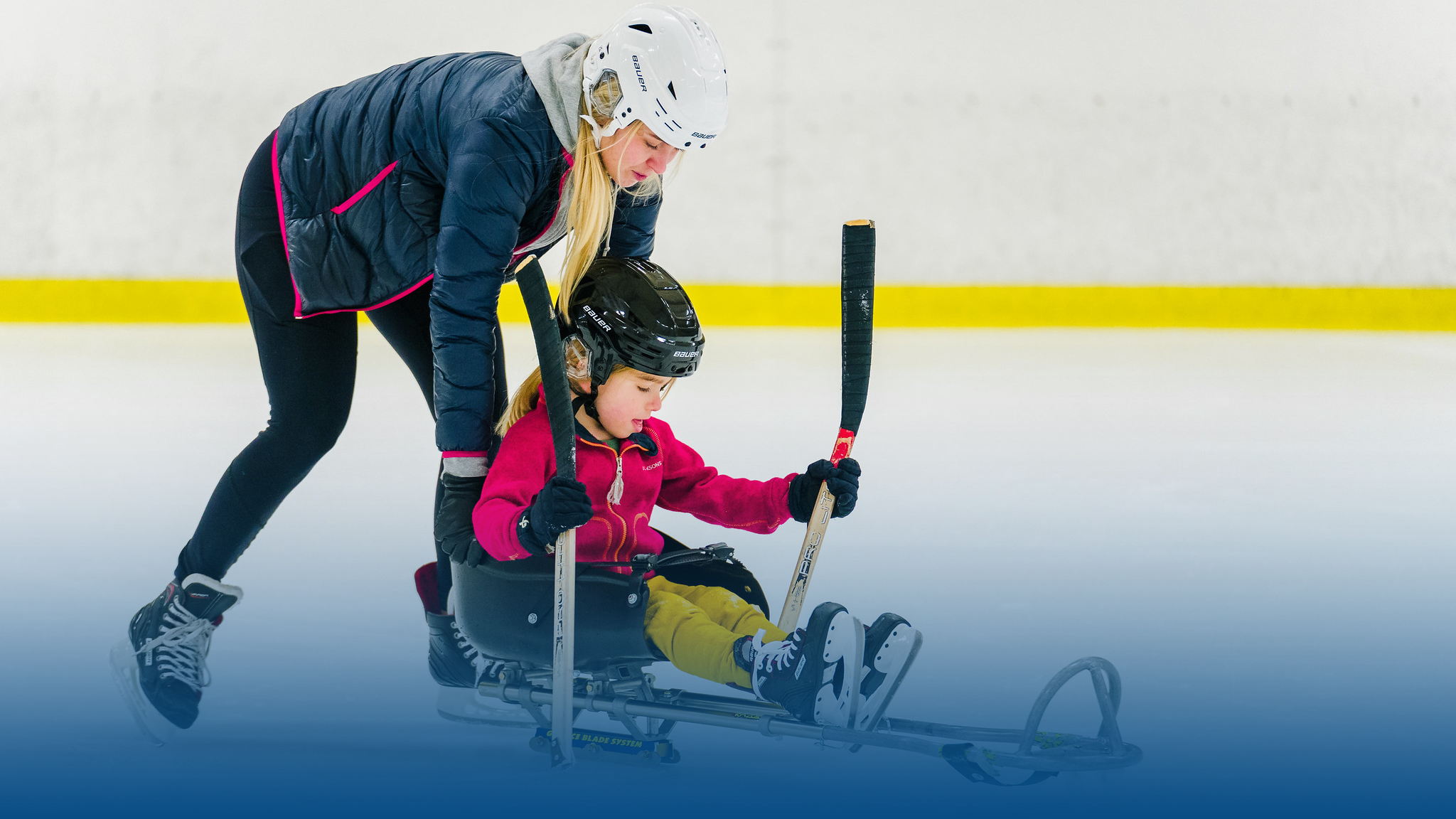 En ledare hjälper liten flicka som provar paraishockey.
