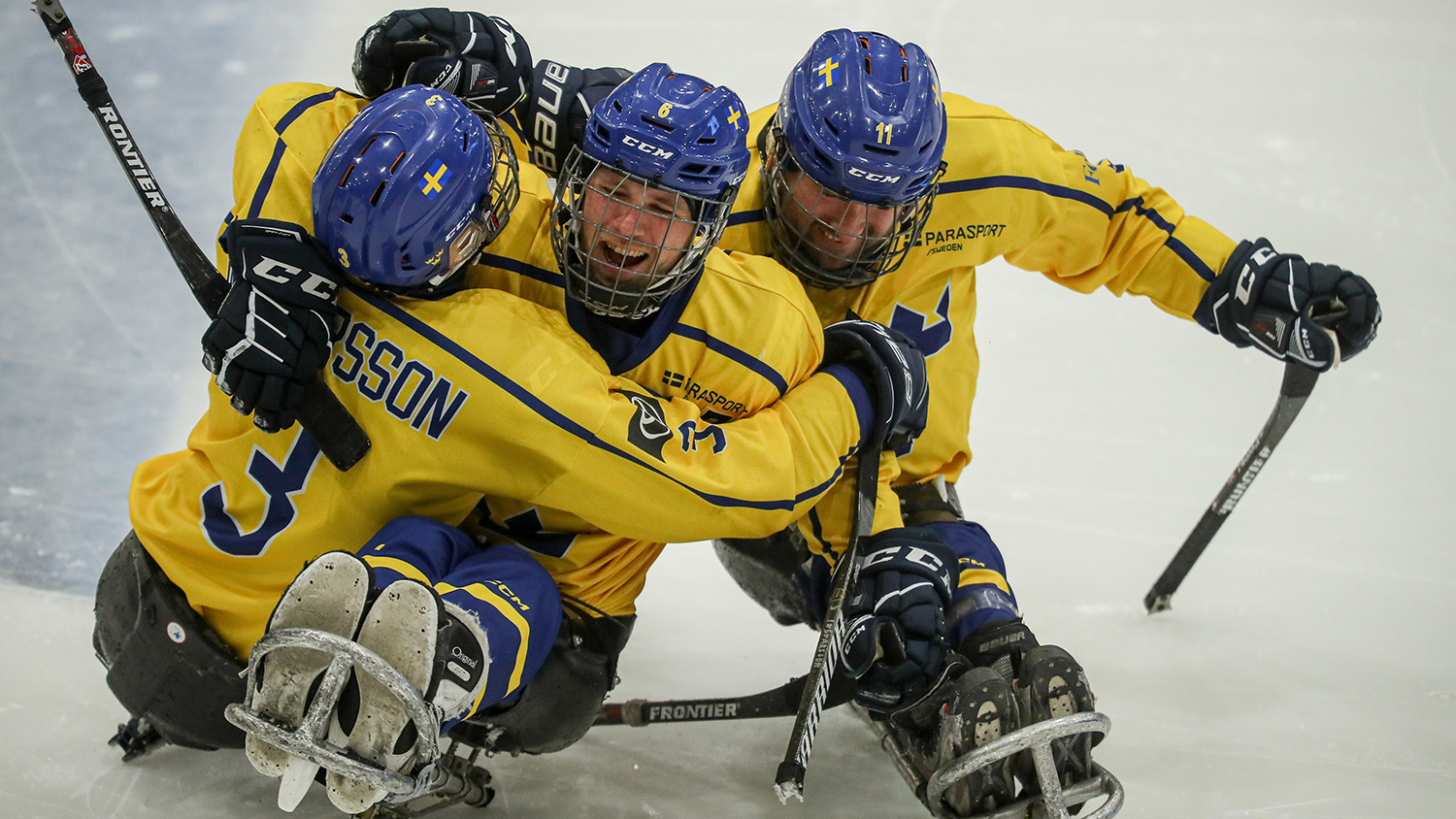 Tre svenska landslagsspelare jublar och kramar om varandra.