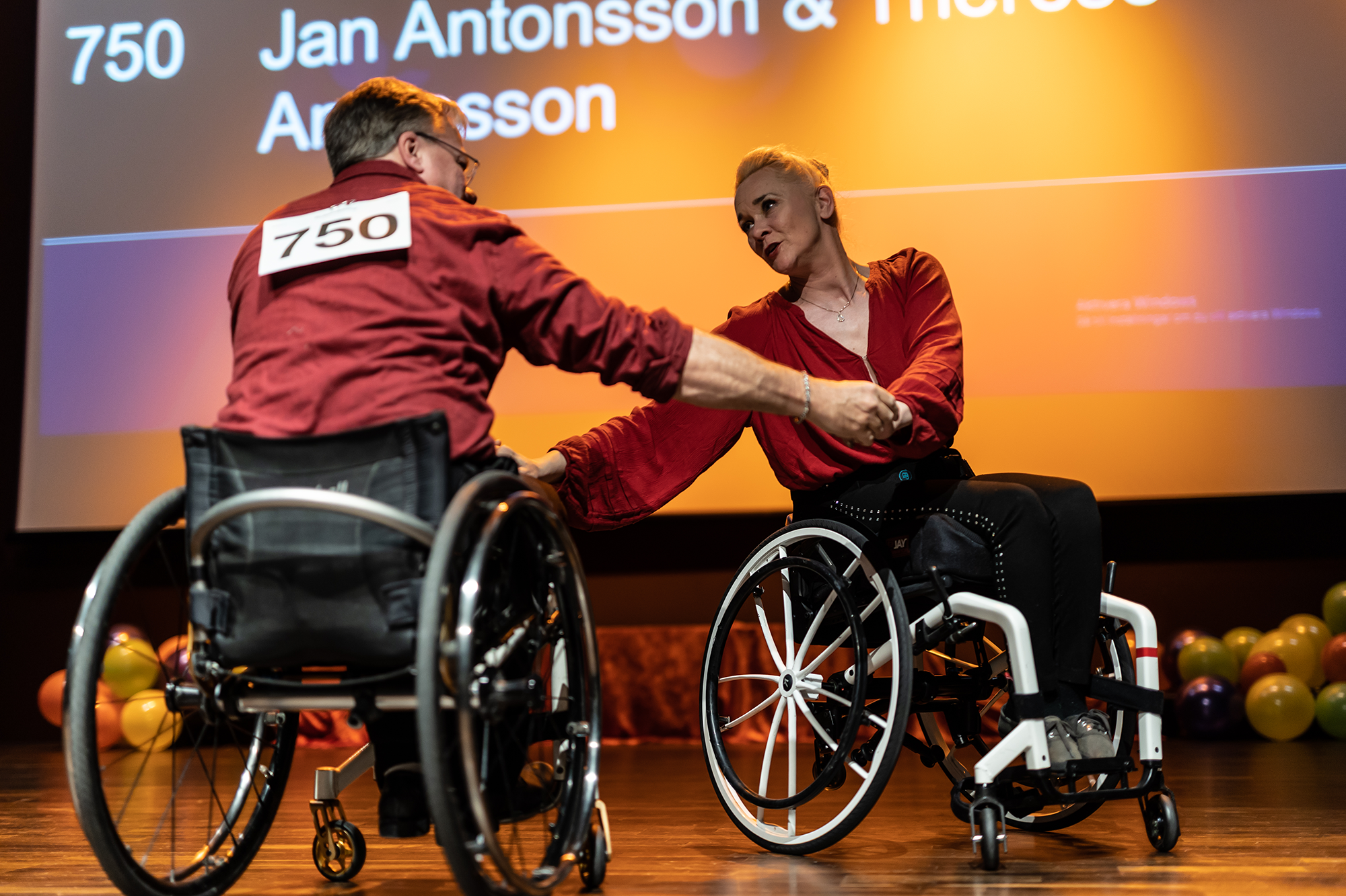 Två personer som använder rullstol dansar på en tävling.
